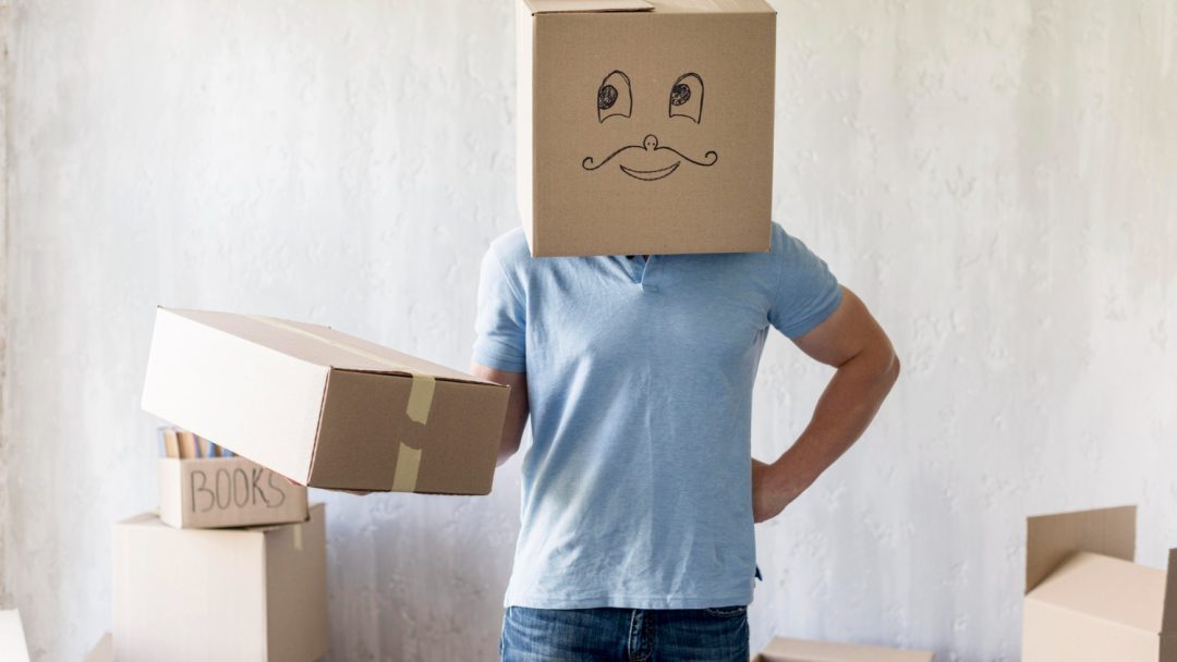 front-view-man-with-box-head-posing-while-packing-move